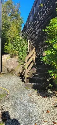 a stairway leading up to a stone wall with a train at Casa Gamle Bergen in Bergen