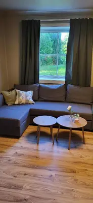 a living room with a blue couch and two tables at Casa Gamle Bergen in Bergen