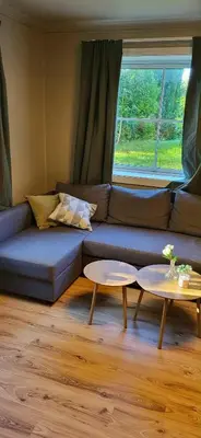 a living room with a blue couch and two tables at Casa Gamle Bergen in Bergen