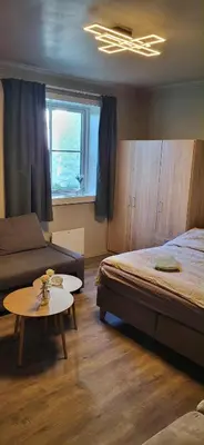 a bedroom with a bed and a table and a couch at Casa Gamle Bergen in Bergen