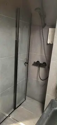 a shower with a shower head in a bathroom at Casa Gamle Bergen in Bergen