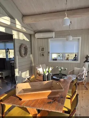 a living room with a wooden table and chairs at Feriebolig Fannrem in Torshus