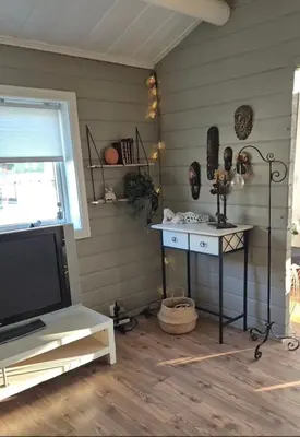 a living room with a tv and a table with a tv at Feriebolig Fannrem in Torshus