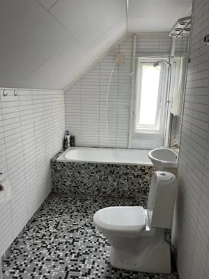 a bathroom with a toilet and a sink and a tub at Loft apartment with 3 bedrooms in Trondheim