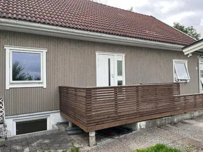 a house with a wooden deck in front of it at Loft apartment with 3 bedrooms in Trondheim