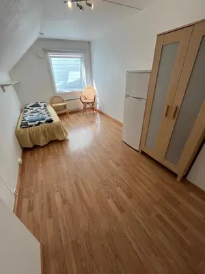 a room with a bed and a refrigerator in it at Loft apartment with 3 bedrooms in Trondheim