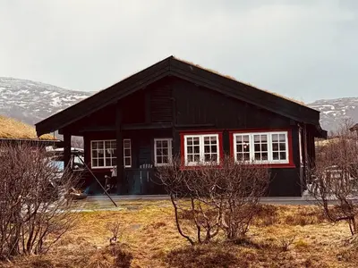 a black house with white windows in a field at Gateway to Hardangervidda - Fireplace, Ski trails, Nature reset in Maurset