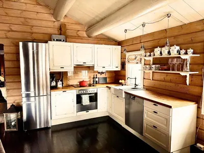 a kitchen with white cabinets and a stainless steel refrigerator at Gateway to Hardangervidda - Fireplace, Ski trails, Nature reset in Maurset