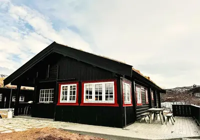 a black building with white windows and a picnic table at Gateway to Hardangervidda - Fireplace, Ski trails, Nature reset in Maurset