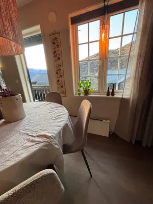 a bedroom with a table and two windows at Røldal ski in ski out in Håra
