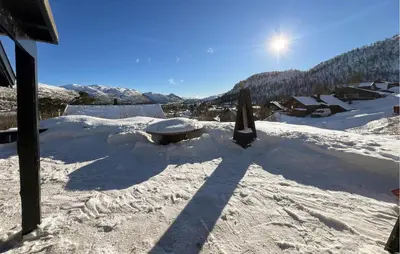 a snow covered roof of a house with the sun behind it at Pet Friendly Home In Hovden I Setesdal in Hovden