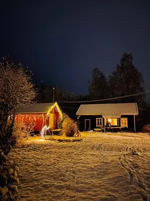 a house is lit up at night in front at Old Farmhouse Retreat with jacuzzi and sauna in Eidsvoll