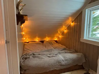 a bed in a room with lights on the wall at Old Farmhouse Retreat with jacuzzi and sauna in Eidsvoll