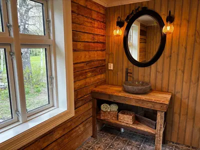 a bathroom with a sink and a mirror at Old Farmhouse Retreat with jacuzzi and sauna in Eidsvoll