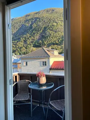 a table and chairs on a balcony with a view at Leilighet Rjukan sentrum in Rjukan