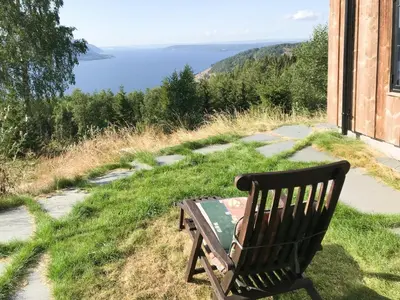 a bench sitting on the grass next to a building at Private Cabin With Stunning Views Near Oslo in Eina
