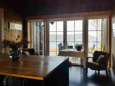 a living room with a table and large windows at Private Cabin With Stunning Views Near Oslo in Eina