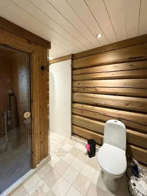 a bathroom with a toilet and a wooden wall at Timber Cabin With Views Over Golsfjellet in Gol