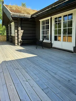 a porch of a house with a chair on it at Timber Cabin With Views Over Golsfjellet in Gol