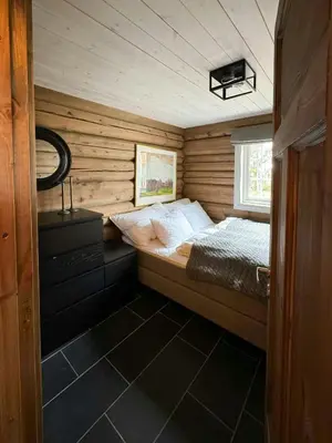 a small bedroom with a bed in a wooden cabin at Timber Cabin With Views Over Golsfjellet in Gol