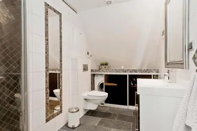 a white bathroom with a toilet and a sink at DINBNB Apartments l 200m to Bryggen l Luxury 2 BR l 2min to Floibanen in Bergen