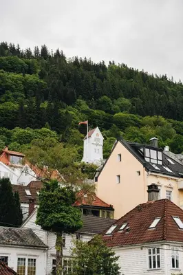 a group of houses with a mountain in the background at DINBNB Apartments l 200m to Bryggen l Luxury 2 BR l 2min to Floibanen in Bergen