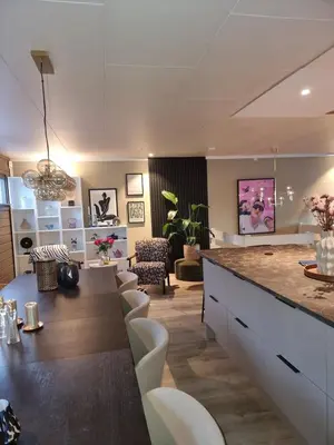 a kitchen and living room with a counter and chairs at Modern semi-detached house with free parking in Lillehammer