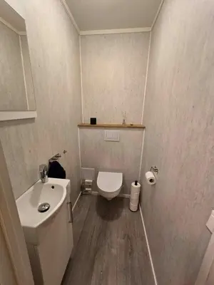a small bathroom with a toilet and a sink at Modern semi-detached house with free parking in Lillehammer