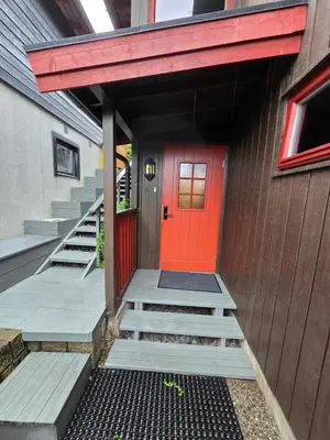 a red door on the side of a building with stairs at Modern semi-detached house with free parking in Lillehammer