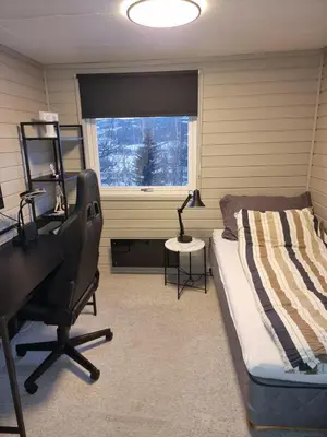 a bedroom with a bed and a desk and a chair at Modern semi-detached house with free parking in Lillehammer