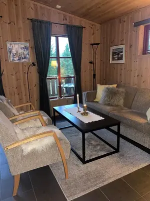 a living room with a couch and a coffee table at Adventurous cabin cozy on Sjusjøen with sauna! in Sjusjøen