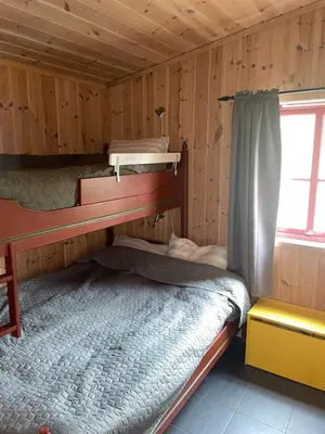 a bedroom with two bunk beds in a cabin at Adventurous cabin cozy on Sjusjøen with sauna! in Sjusjøen