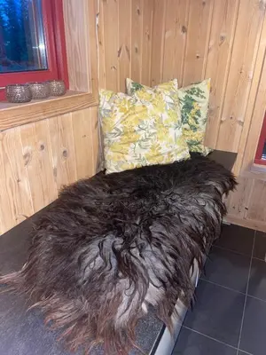 a bed in a room with a long brown blanket at Adventurous cabin cozy on Sjusjøen with sauna! in Sjusjøen
