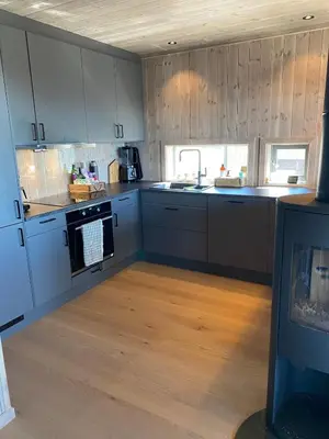 a kitchen with gray cabinets and a wooden floor at Cabin at Norefjell! Perfect for families with children in Runn