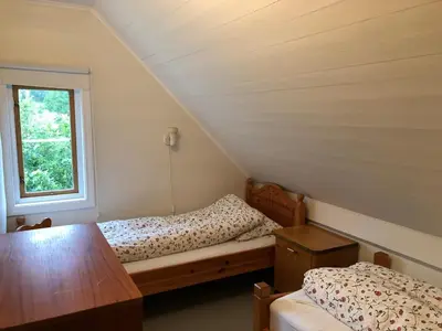 a bedroom with a bed and a window at Seaside apartment in farmhouse close to nature in Husevåg