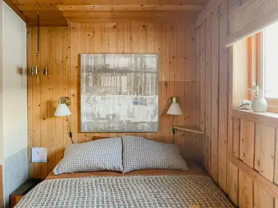 a bedroom with a bed in a wooden wall at Cozy Cabin In Scenic Vøringsfoss in Garden