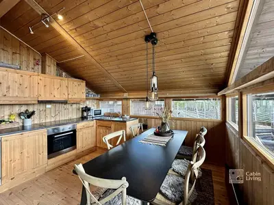 a kitchen with a black table and chairs in it at Modern mountain cabin Ski in-out 2 Bathrooms in Ringsaker