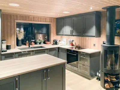 a kitchen with black cabinets and a stove at Family Cabin With A View Of Skeikampen in Svingvoll