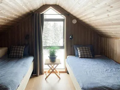 two beds in a room with a window at Family Cabin With A View Of Skeikampen in Svingvoll
