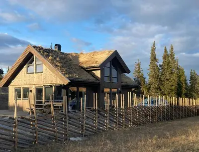 a house with a wooden fence in front of it at Family Cabin With A View Of Skeikampen in Svingvoll