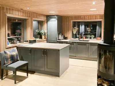 a kitchen with gray cabinets and a counter and a chair at Family Cabin With A View Of Skeikampen in Svingvoll