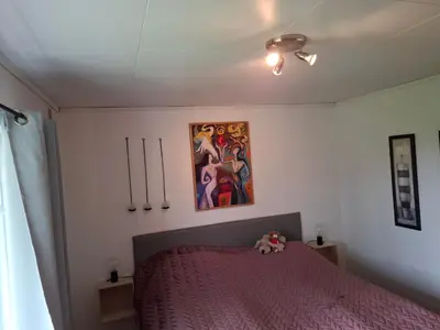 a bedroom with a bed with a pink bedspread at Apartment in the heart of Sunnmore in Vigra