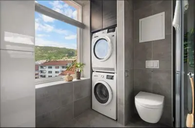 a washing machine in a bathroom with a window at Rålekker 2-roms leilighet in Bergen