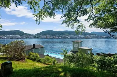 a view of a body of water with a house at Rålekker 2-roms leilighet in Bergen