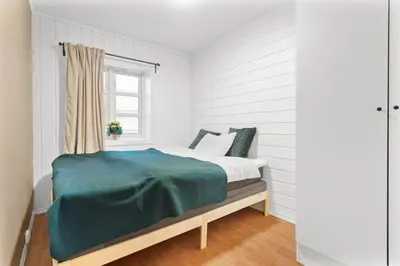 a bed in a white room with a window at Staymate apartments. Trondheim sentrum in Trondheim