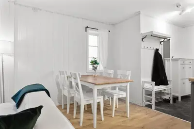 a white dining room with a table and chairs at Staymate apartments. Trondheim sentrum in Trondheim
