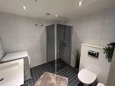 a bathroom with a shower and a toilet at Staymate apartment at Lade in Trondheim