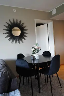 a dining room table with chairs and a mirror at Staymate apartment at Lade in Trondheim