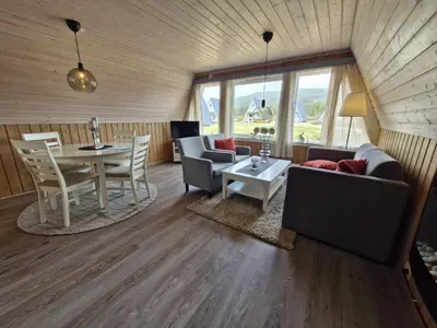 a living room with a couch and a table and chairs at Fjellhytte i Valdres, rett ved nasjonalpark og turstier in Robøle