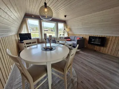 a room with a table and chairs and a living room at Fjellhytte i Valdres, rett ved nasjonalpark og turstier in Robøle